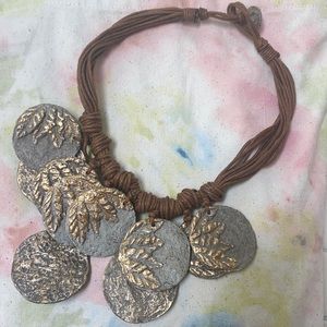 Decorative paper mache disk necklace.